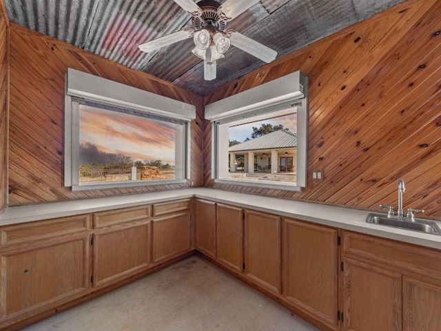 interior space with wooden walls, sink, and ceiling fan