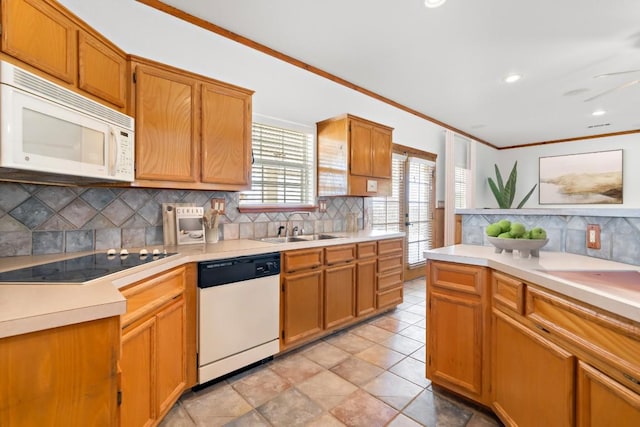 kitchen featuring decorative backsplash, white appliances, ceiling fan, crown molding, and sink