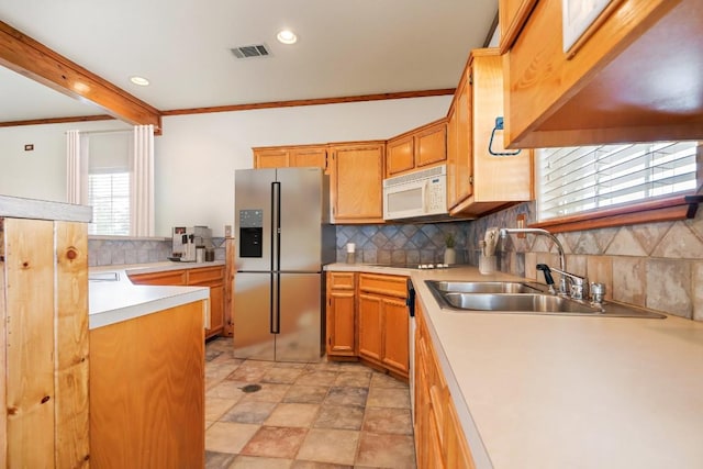 kitchen with stainless steel fridge, ornamental molding, sink, and tasteful backsplash