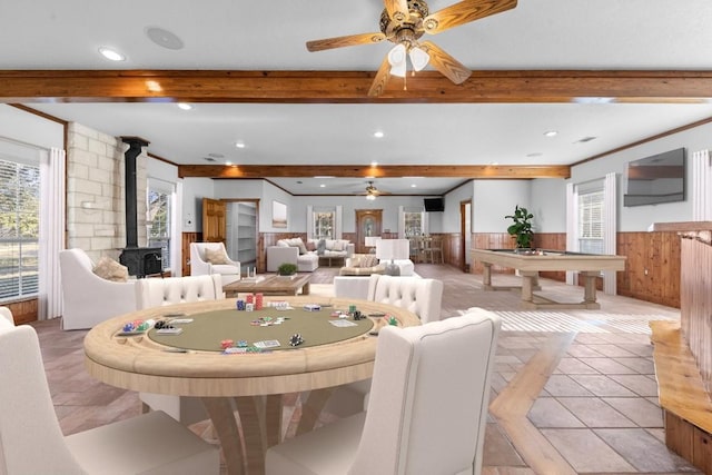 tiled dining area with beamed ceiling, a wood stove, ceiling fan, and pool table