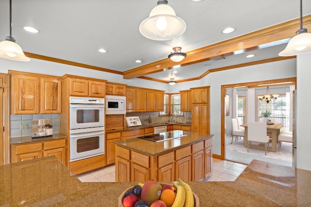 kitchen featuring decorative backsplash, white appliances, a center island, and hanging light fixtures