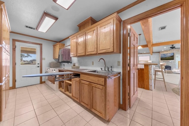 kitchen featuring beam ceiling, ceiling fan, a kitchen breakfast bar, crown molding, and light tile patterned flooring