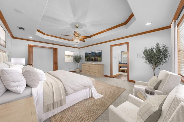 bedroom with ceiling fan, ensuite bathroom, crown molding, and a tray ceiling