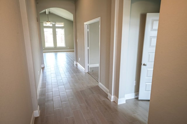 hall featuring hardwood / wood-style floors and vaulted ceiling