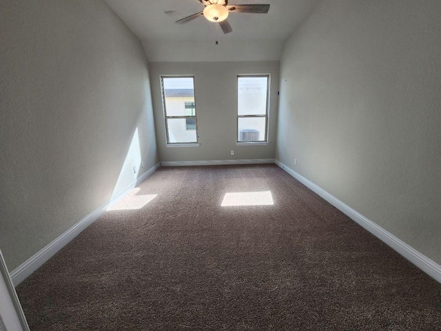 spare room featuring vaulted ceiling, carpet flooring, and baseboards