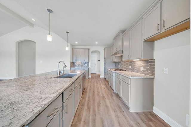 413 Canton Chase, Cibolo, TX 78108 - kitchen with a sink, arched walkways, under cabinet range hood, light stone countertops, and recessed lighting