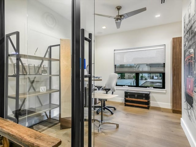 office with light wood-type flooring and ceiling fan