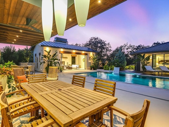 pool at dusk featuring a patio