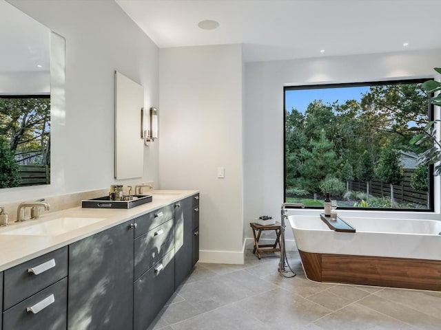 bathroom with tile patterned flooring, vanity, and a washtub