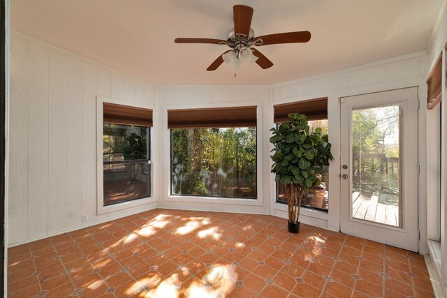 unfurnished sunroom with ceiling fan