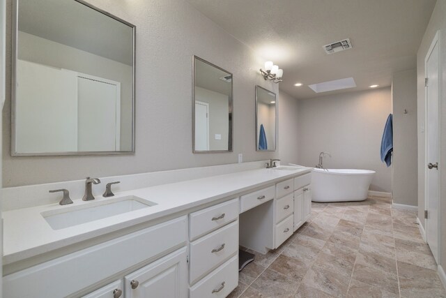 bathroom with a tub to relax in and vanity