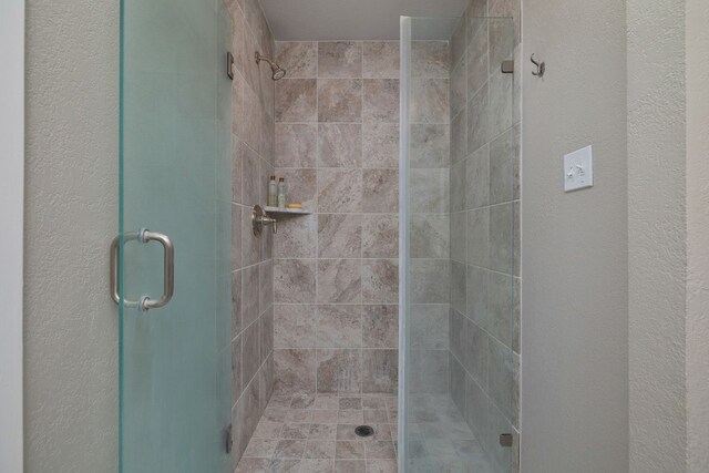 bathroom featuring a shower with shower door