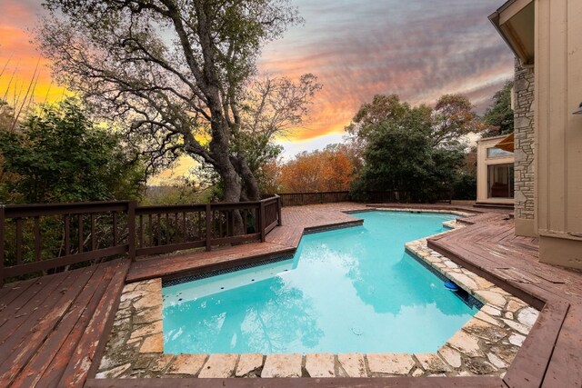 pool at dusk with a wooden deck