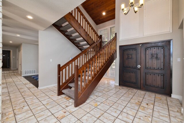 foyer entrance with vaulted ceiling, wood ceiling, and a chandelier