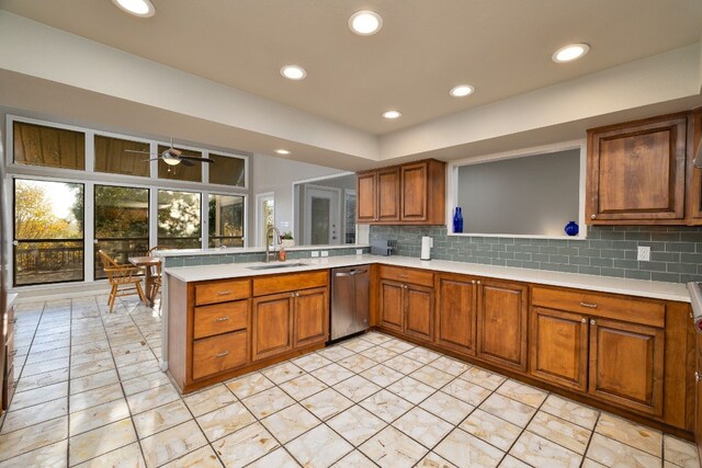 kitchen featuring dishwasher, sink, ceiling fan, tasteful backsplash, and kitchen peninsula