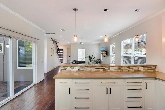 kitchen featuring dark wood-type flooring, white cabinets, ceiling fan, decorative light fixtures, and butcher block counters