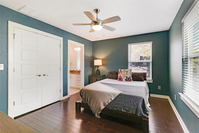 bedroom with connected bathroom, a closet, ceiling fan, and dark wood-type flooring