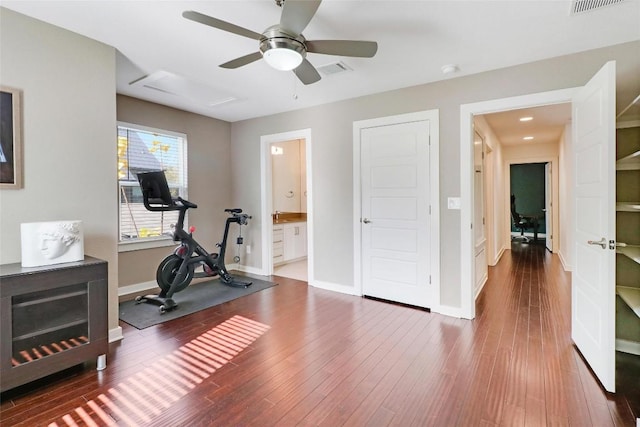 exercise room with ceiling fan and dark wood-type flooring