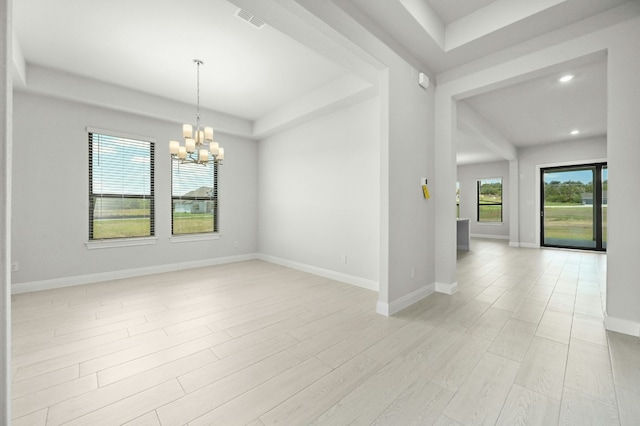 unfurnished room with light hardwood / wood-style floors and an inviting chandelier