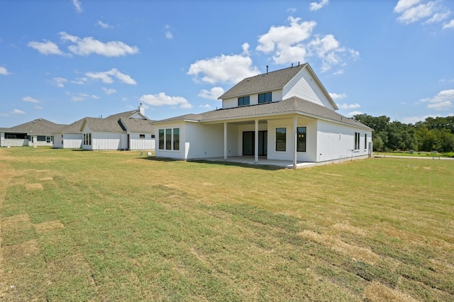 back of property with a yard and a patio