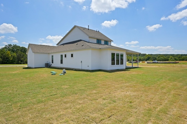 rear view of house featuring a yard and cooling unit