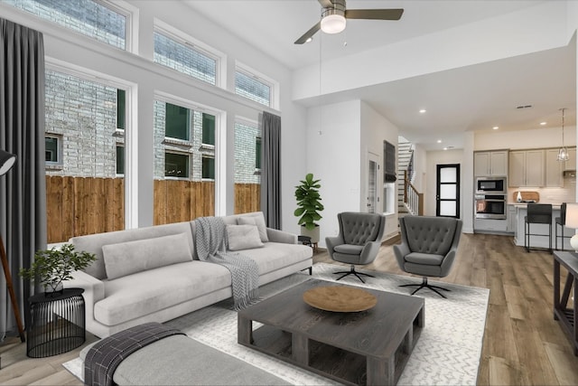 living room with ceiling fan and light wood-type flooring