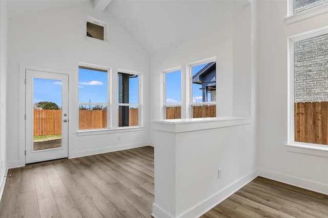 unfurnished sunroom featuring lofted ceiling with beams and a healthy amount of sunlight