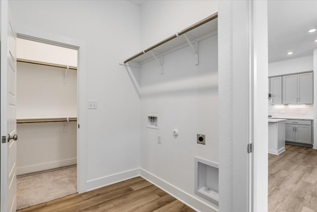 laundry area with hookup for a gas dryer, electric dryer hookup, hookup for a washing machine, and light hardwood / wood-style floors