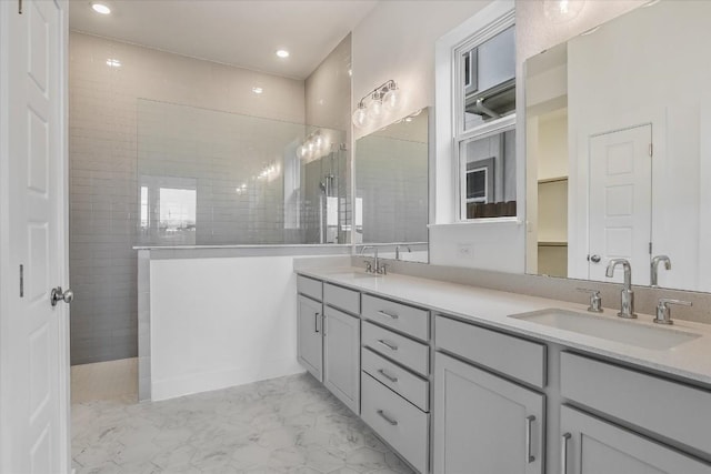 bathroom with tiled shower and vanity