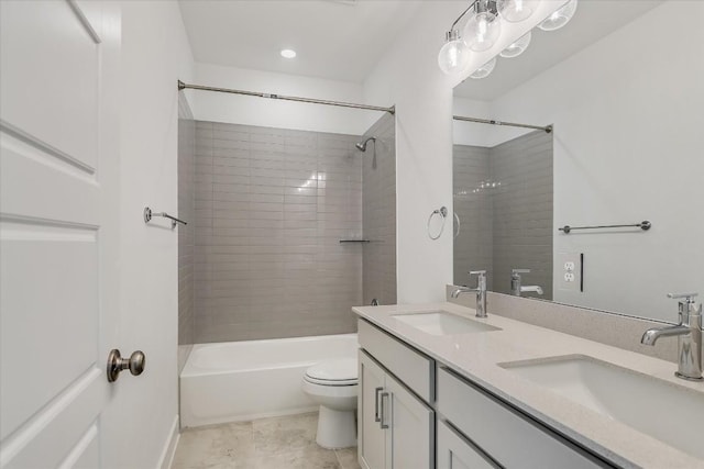 full bathroom featuring tiled shower / bath, vanity, and toilet