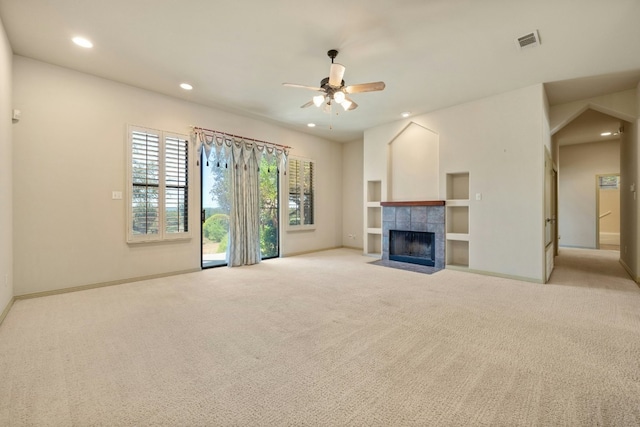 unfurnished living room featuring ceiling fan, light carpet, and a tiled fireplace