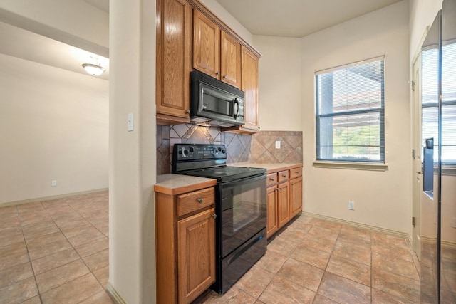 kitchen featuring tasteful backsplash, plenty of natural light, and black appliances