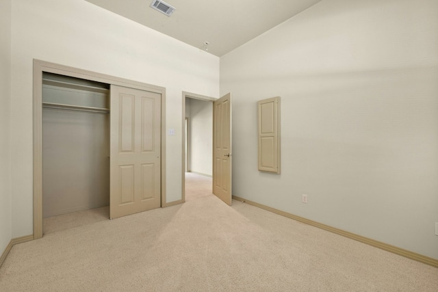 unfurnished bedroom with light carpet, a closet, and high vaulted ceiling