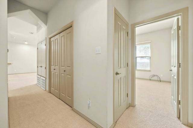 hall with light colored carpet