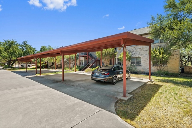 view of parking / parking lot featuring a carport and a yard