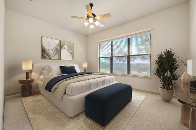 bedroom with ceiling fan and light colored carpet