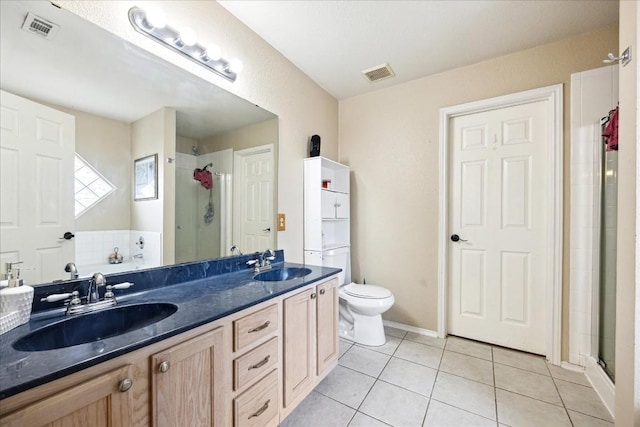 bathroom featuring tile patterned floors, vanity, a shower with shower door, and toilet