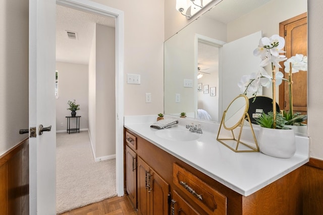 bathroom with vanity, ceiling fan, parquet flooring, and a textured ceiling