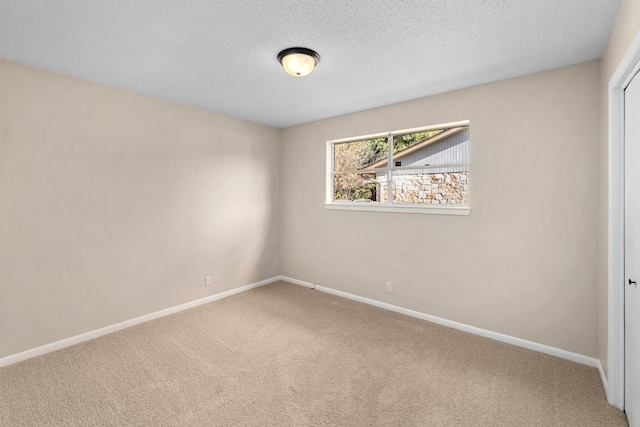 carpeted spare room with a textured ceiling