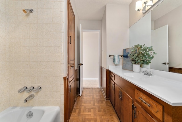 bathroom with parquet flooring, vanity, and a textured ceiling