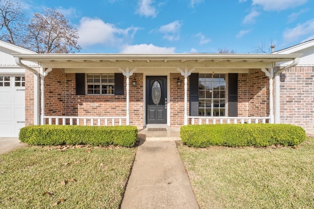 property entrance featuring a porch, a garage, and a lawn