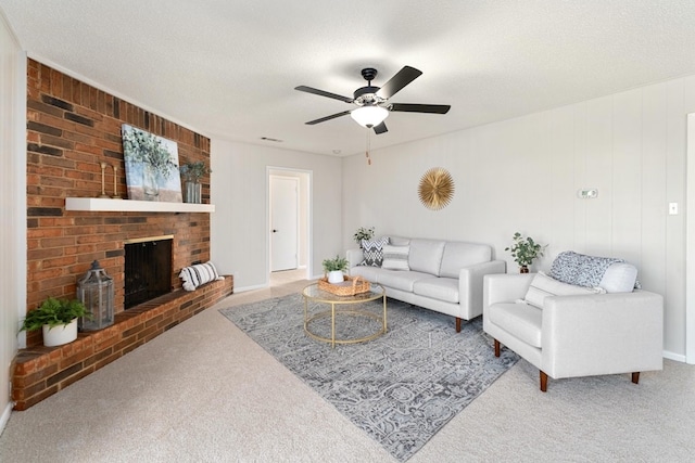 carpeted living room featuring a fireplace, ceiling fan, a textured ceiling, and wooden walls