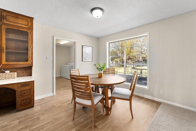 dining space with light hardwood / wood-style flooring and a textured ceiling