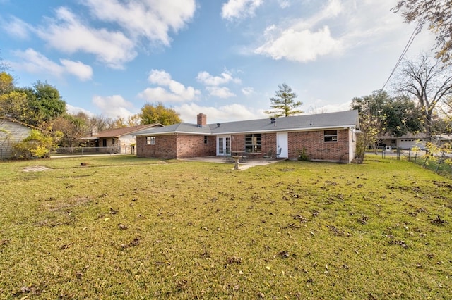 rear view of house featuring a patio area and a lawn