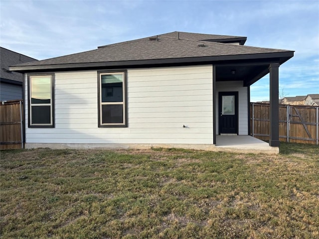 rear view of house with a yard and a patio