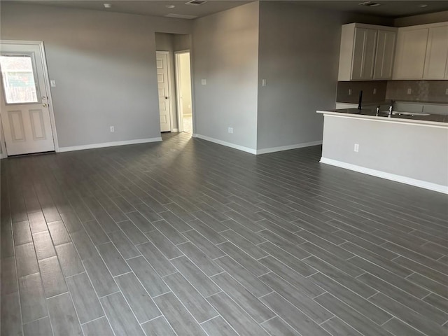 unfurnished living room with sink and dark hardwood / wood-style floors