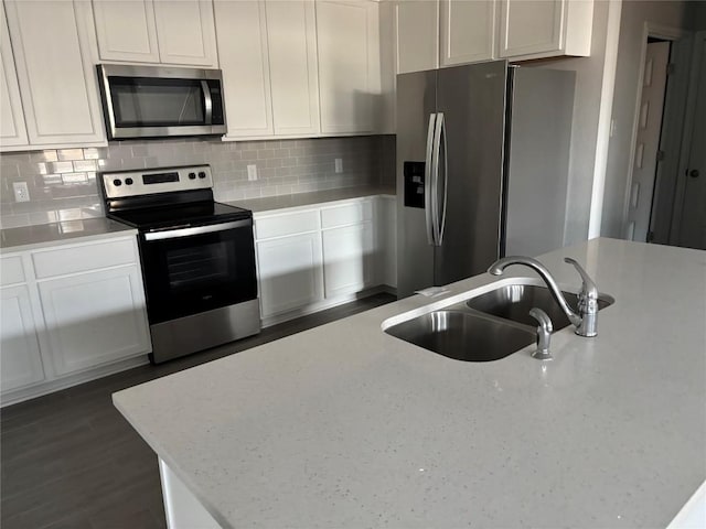 kitchen featuring sink, light stone countertops, tasteful backsplash, white cabinetry, and stainless steel appliances