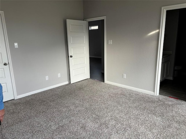 unfurnished bedroom with carpet flooring and ensuite bath