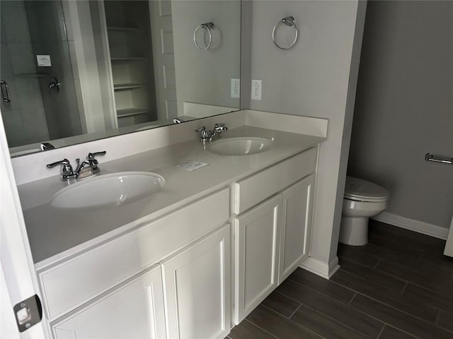 bathroom with wood-type flooring, vanity, toilet, and walk in shower