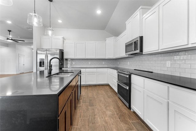 kitchen featuring stainless steel appliances, white cabinetry, hanging light fixtures, and sink